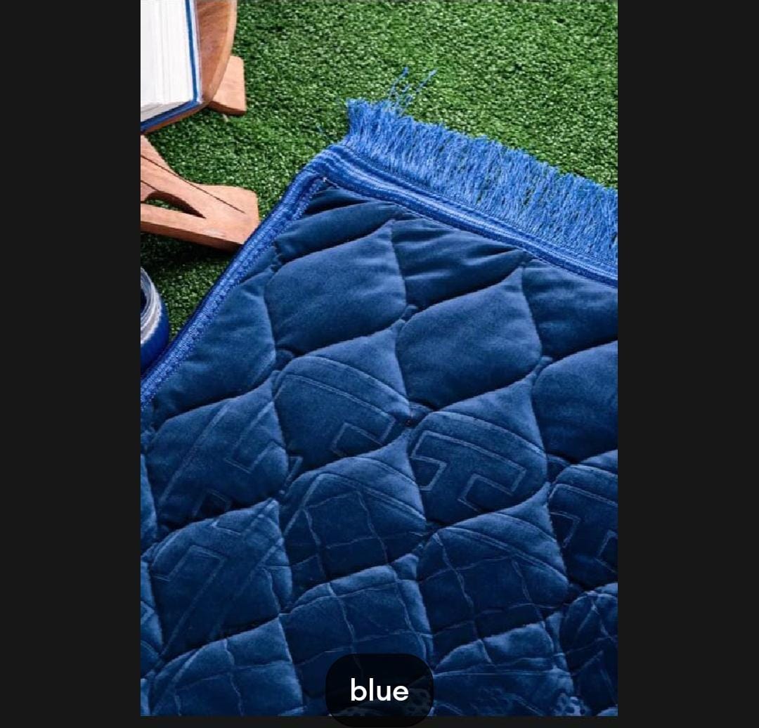 Blue textured mat with fringes on a grassy background