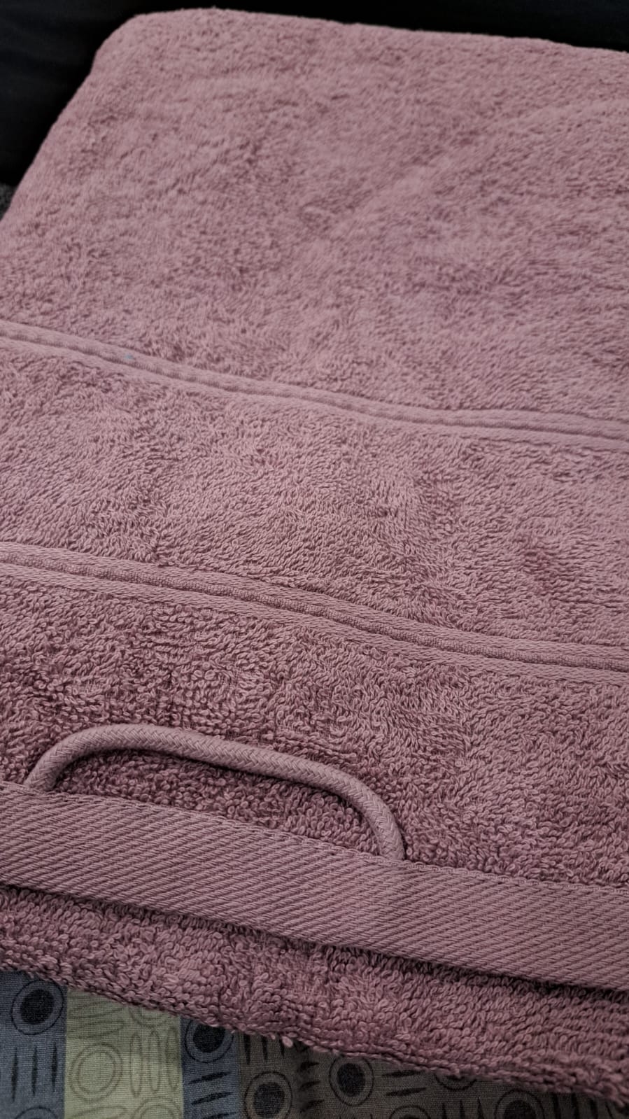 Close-up of a purple towel with visible texture and handle.