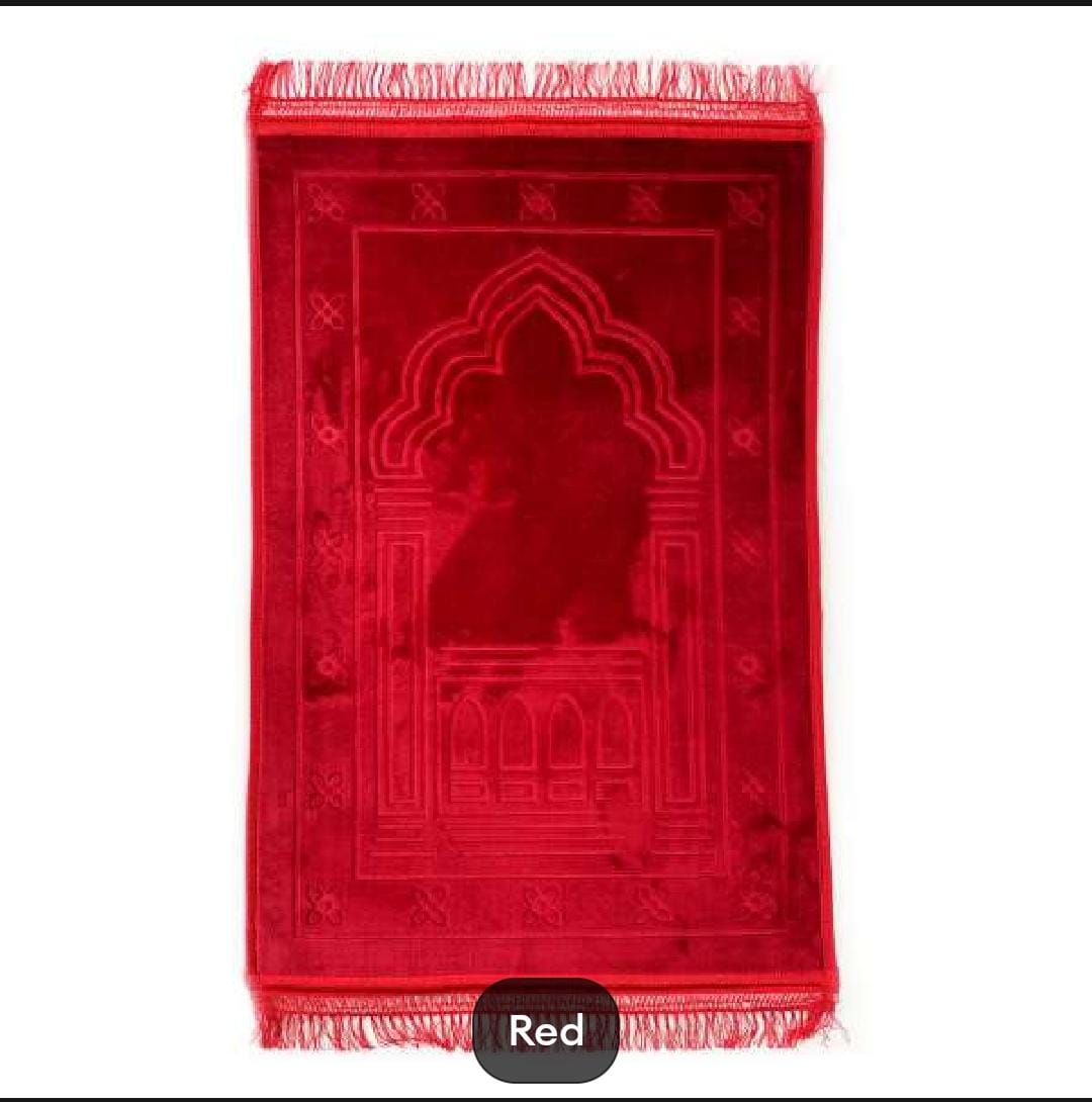 Red prayer mat with a geometric design on a white background