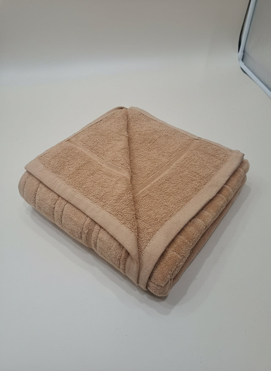 Folded brown towel on a light-colored floor