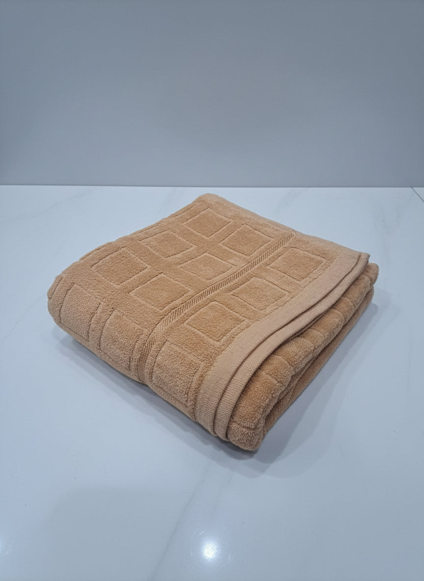 Brown towel with diamond pattern on a white tiled floor