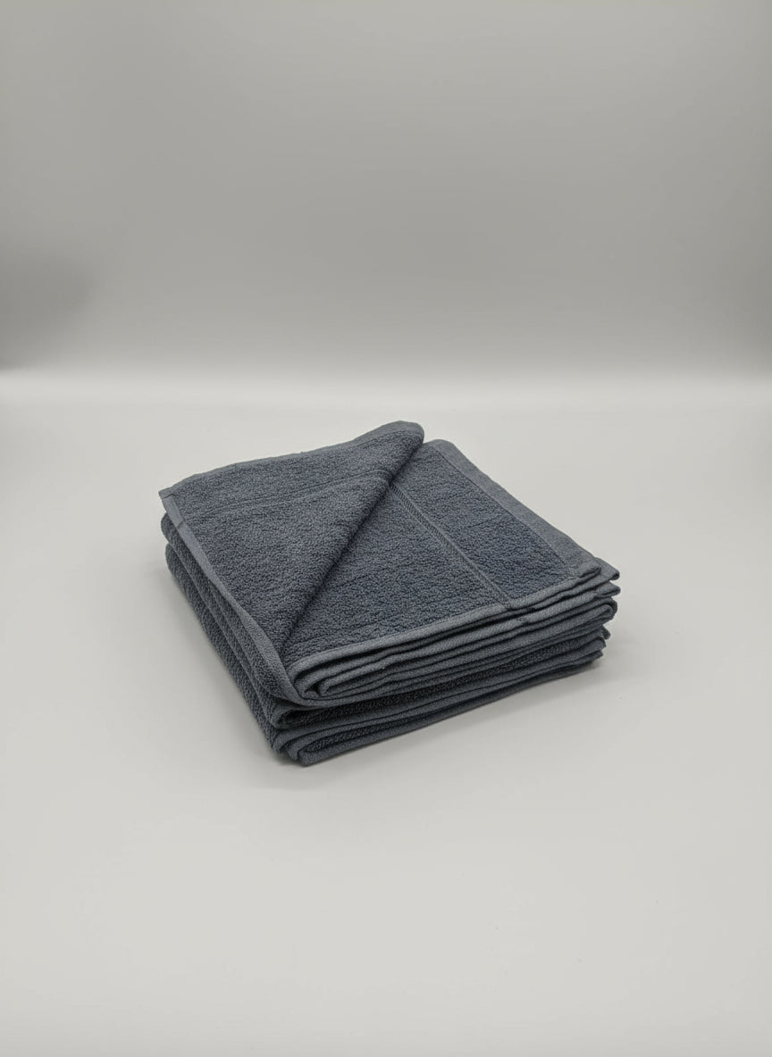 Folded gray towel on a cardboard box with a tiled floor background