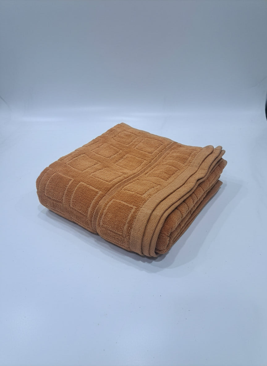 Brown towel on a white tiled floor