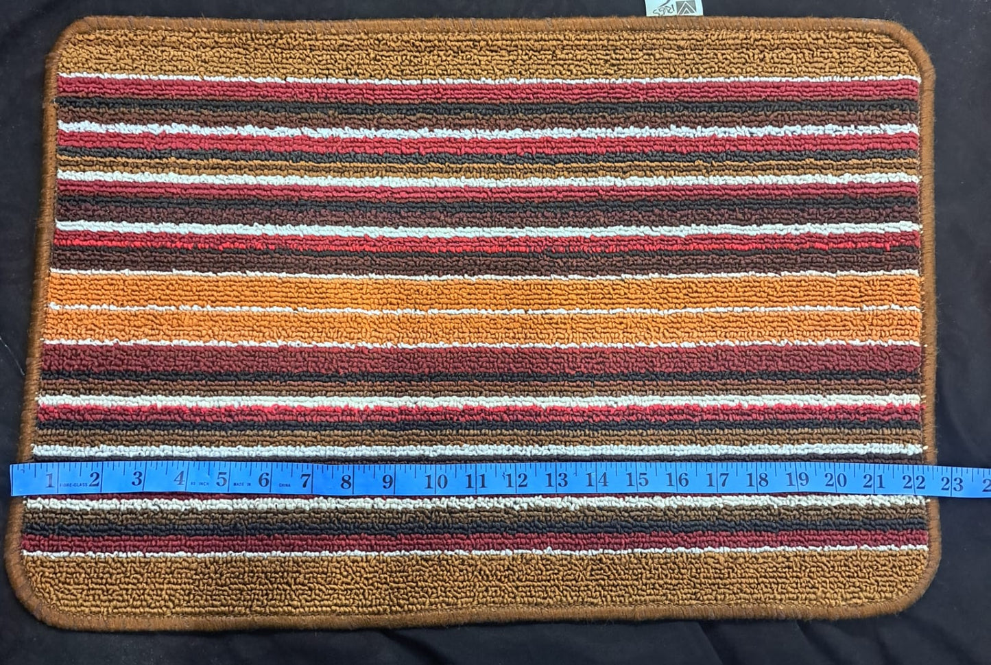Striped doormat with a measuring tape indicating its width