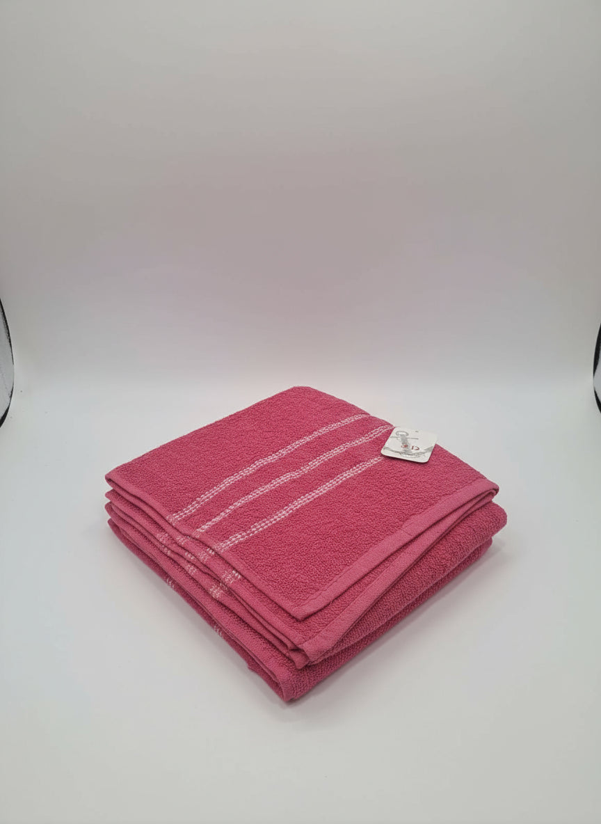 Pink towel with a tag on a white tiled floor