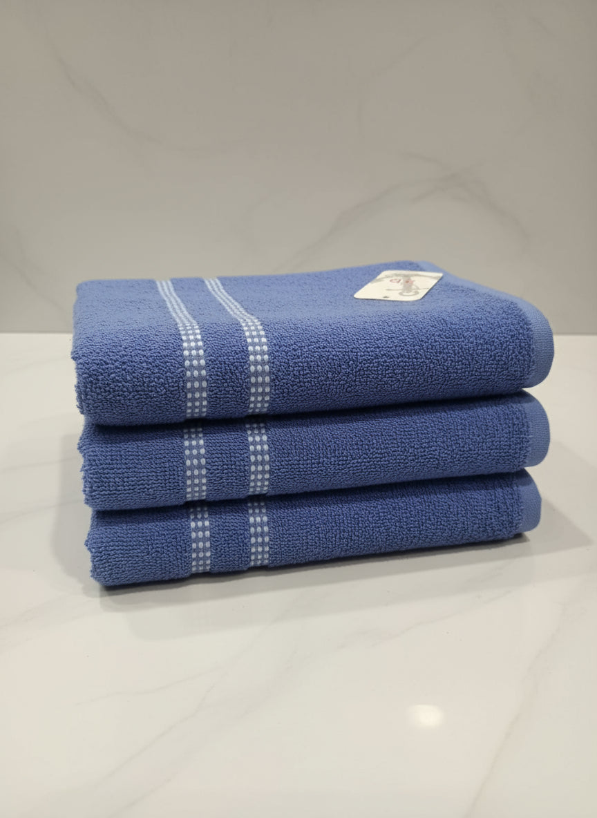 Blue towel with a tag on a tiled floor