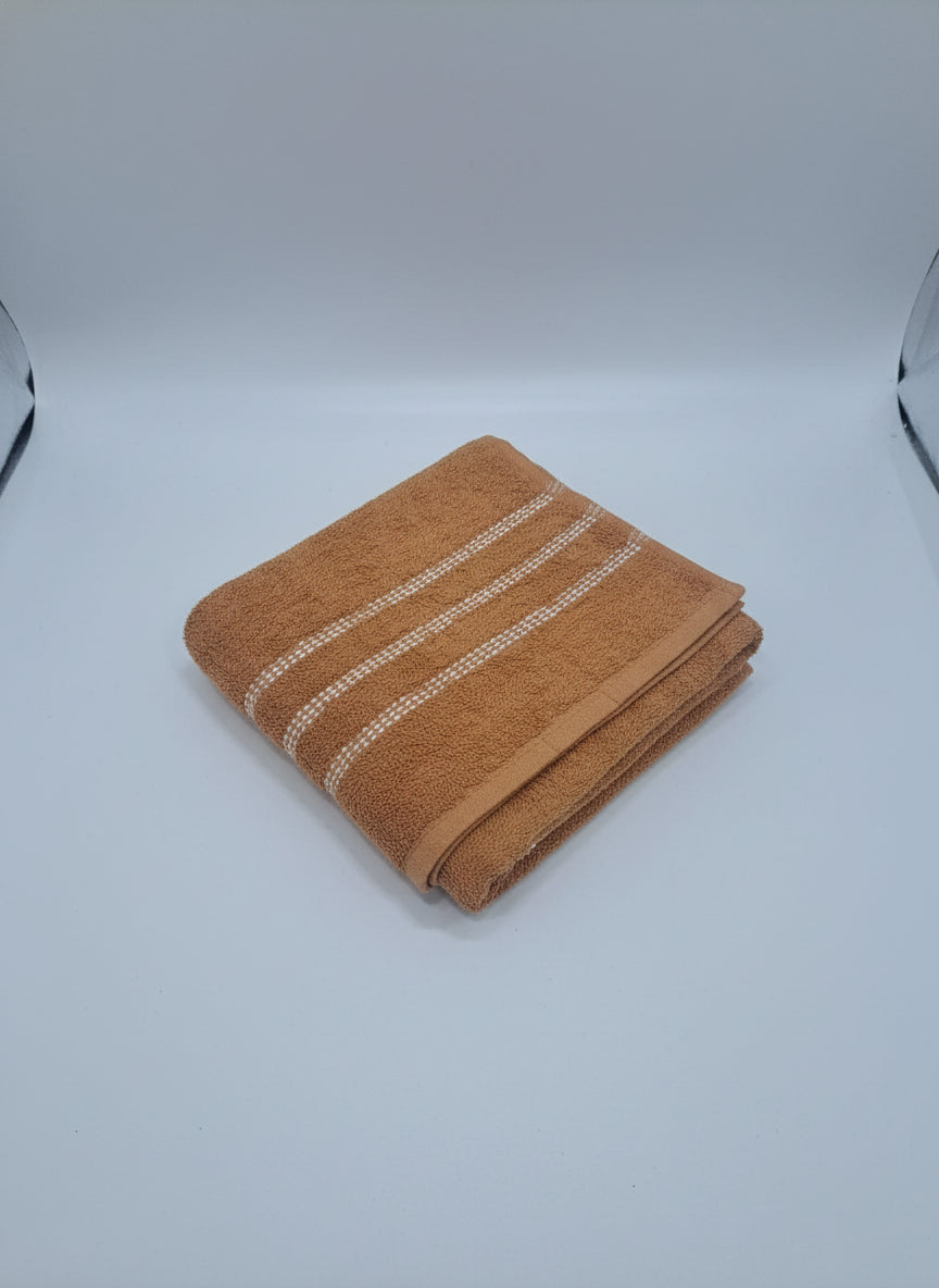 Brown towel with white stripes on a beige surface
