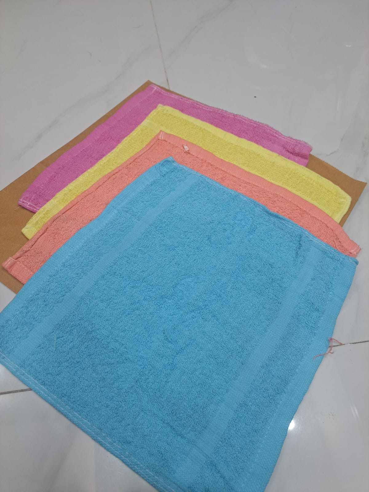Set of colorful microfiber cloths on a white tiled floor