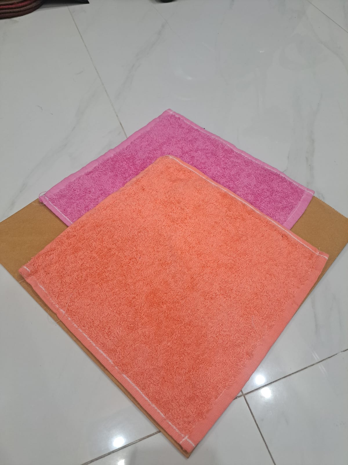 Two colorful towels on a tiled floor