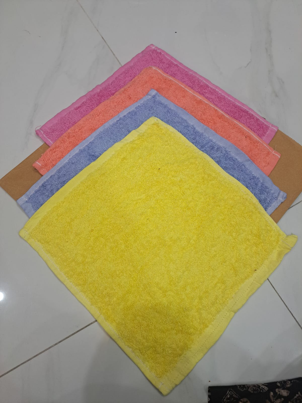 Set of colorful microfiber cloths on a white tiled floor