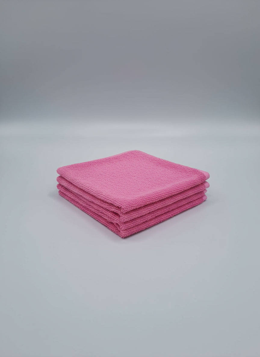 Pink towel on a cardboard square on a tiled floor