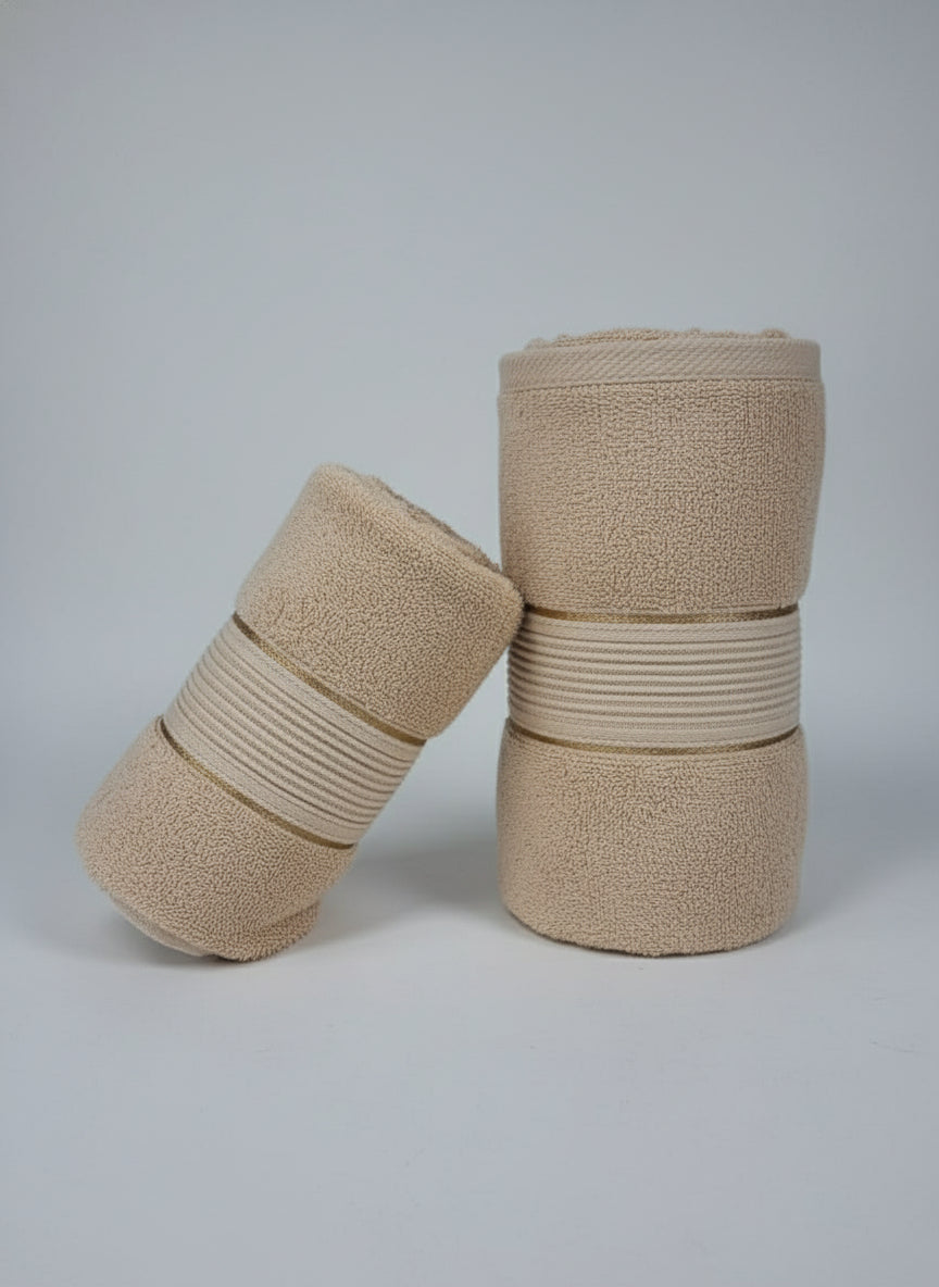 Two beige rolled-up towels on a black background