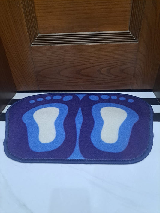 Blue foot-shaped doormat in front of a wooden door