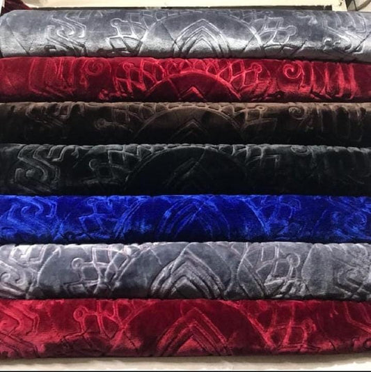 Stack of embossed velvet fabric in various colors.