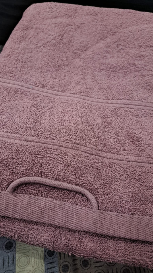 Close-up of a purple towel with visible texture and handle.