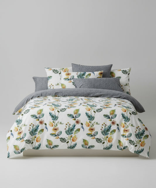 Floral bedding set with gray pillows on a bed, featuring the Feather Collection logo.