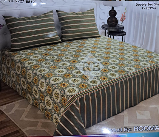 Bed with a floral patterned bedspread and striped pillows in a room setting.