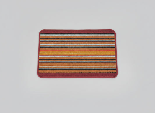 Multicolored striped rug with a red border on a black background