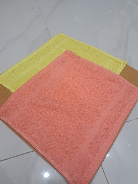 Two bath mats, one pink and one yellow, on a tiled floor.